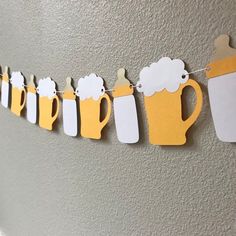 a paper garland with beer mugs hanging from it's sides on a wall