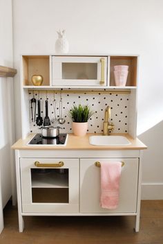 a kitchen with white cabinets and black polka dots on the wall, including a sink