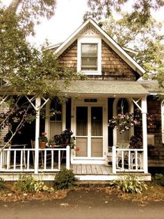 a small house with flowers on the front porch