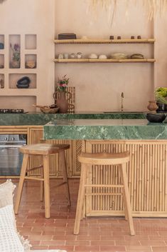 a kitchen with green marble counter tops and wooden stools