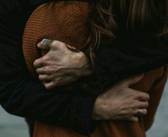 two people embracing each other with their arms wrapped around one person's chest and the other holding his arm