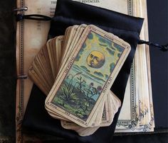 four tarot cards are sitting on top of an old book and some other items