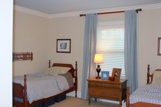 two twin beds in a bedroom with blue curtains