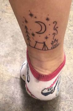 a person with a small tattoo on their leg and foot, which has camping symbols all over it