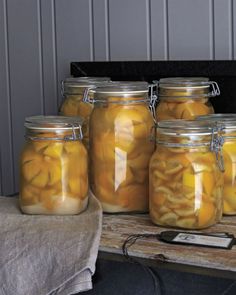 several jars filled with pickles sitting on top of a table next to a cell phone