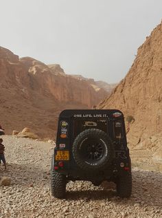 a jeep is parked in the desert near some mountains