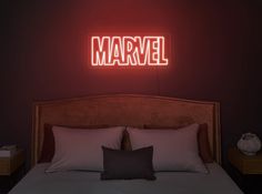 a bed in a room with a neon sign above it that reads'marvel '