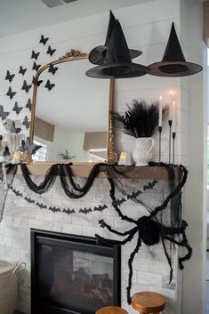 a fireplace decorated for halloween with bats and spider webs