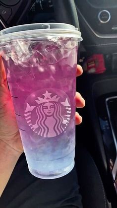 a person holding up a pink drink in their hand