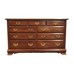 a wooden dresser with many drawers and gold handles