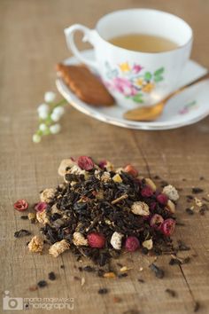 a cup of tea next to some dried berries