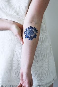 a woman with a blue flower tattoo on her arm