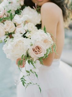 a woman holding a bouquet of white and pink flowers