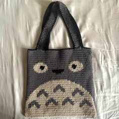 a crocheted totoro bag on a bed