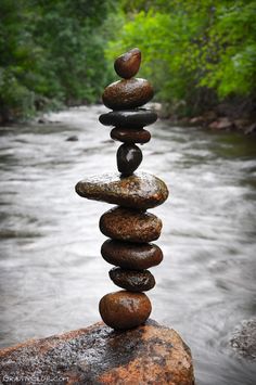 rocks stacked on top of each other in the middle of a river with an inspirational quote