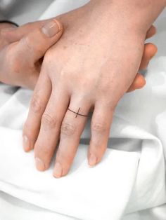 a couple holding each other's hand with a small cross on the middle finger