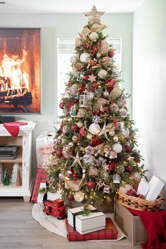 a decorated christmas tree in front of a fireplace