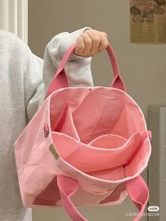 a person holding a pink bag in their hand