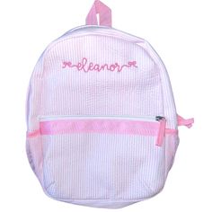 a white backpack with pink trimmings and embroidered name on the front, it is shown