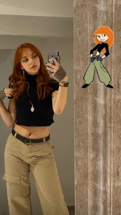 a woman taking a selfie in front of a mirror with an animated character on the wall behind her