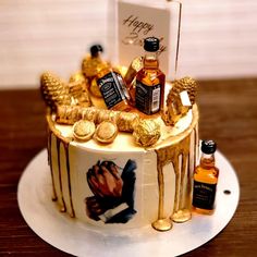 a birthday cake decorated with gold and liquor bottles