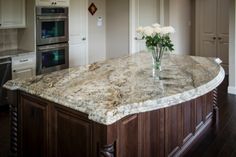 a kitchen with an island in the middle and two ovens next to each other