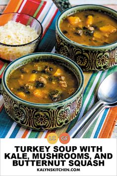 two bowls of turkey soup with kale, mushrooms and butternut squash on a table