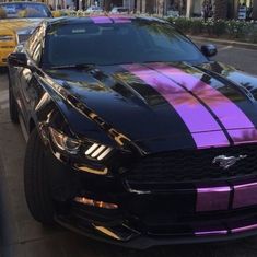 a black car with purple stripes parked on the street