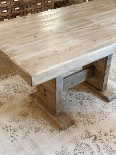 a large wooden table sitting on top of a rug