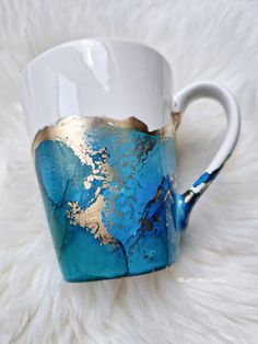 a blue and gold coffee cup sitting on top of a white furnishing area