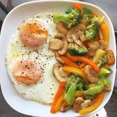 a white plate topped with mushrooms, broccoli and eggs