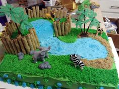 a cake that is shaped like a zoo scene