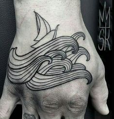 a man's hand with a black and white tattoo on it