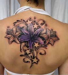 a woman's back tattoo with flowers on it