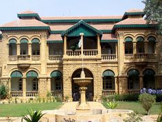 an old building with a fountain in front of it and lots of windows on the second floor