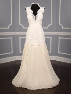 a wedding dress on display in a room with gray walls and white trimmings