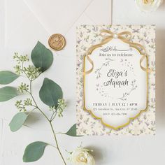 the wedding card is next to some flowers