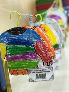 a row of colorful paper elephants hanging from clothes pins with price tags attached to them