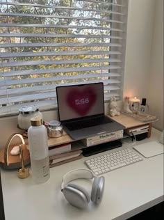 a laptop computer sitting on top of a desk next to headphones and other items