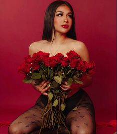 a woman in fishnet stockings holding roses with her hands on her hips and looking at the camera