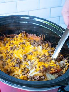 a crock pot filled with ground beef and cheese