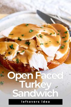 an open faced turkey sandwich with gravy on top and a knife next to it