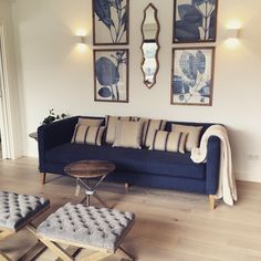 a living room filled with furniture and pictures on the wall