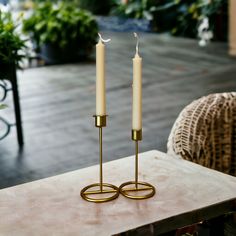 two candles sitting on top of a wooden table