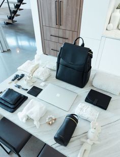 a table with laptops and other items on it, including a handbag in the middle