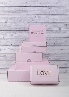 pink boxes stacked on top of each other with the words love in gold foil lettering