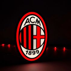 the acm logo is lit up at night with red and white lights around it