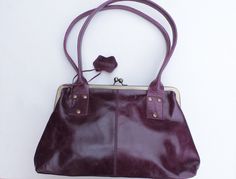 Doris in Purple leather kiss clip, clip frame leather bag with internal compartments, one zipped and another two are open pockets. The lining is waterproof and durable.  This bag has a comfortable rolled shoulder strap.  33x21 and the base is 9,5x32 Strap measures 58cms Inside zip is 18x18 cms and 2 pockets one if which is 13x13 and the smaller open pocket is 8x13 (1 inch = 2.5cms) Leather Shoulder Bag With Hinge Closure, Leather Shoulder Bag With Hinge Closure For Everyday Use, Everyday Use Satchel Shoulder Bag With Hinge Closure, Rectangular Leather Shoulder Bag With Hinge Closure, Leather Hip Bag, Clip Frame, Fanny Bag, Messenger Purse, Leather Roll