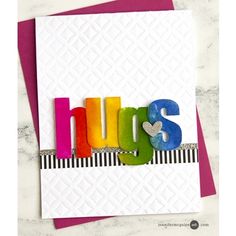 a card with the word hugs spelled out in multicolored letters on top of it