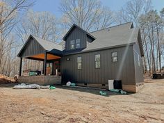 a house is being built in the middle of a forest with trees and dirt around it